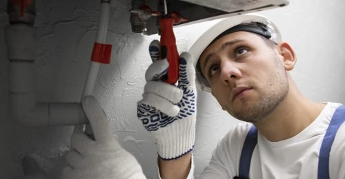 worker-repairing-water-heater worker-repairing-water-heater